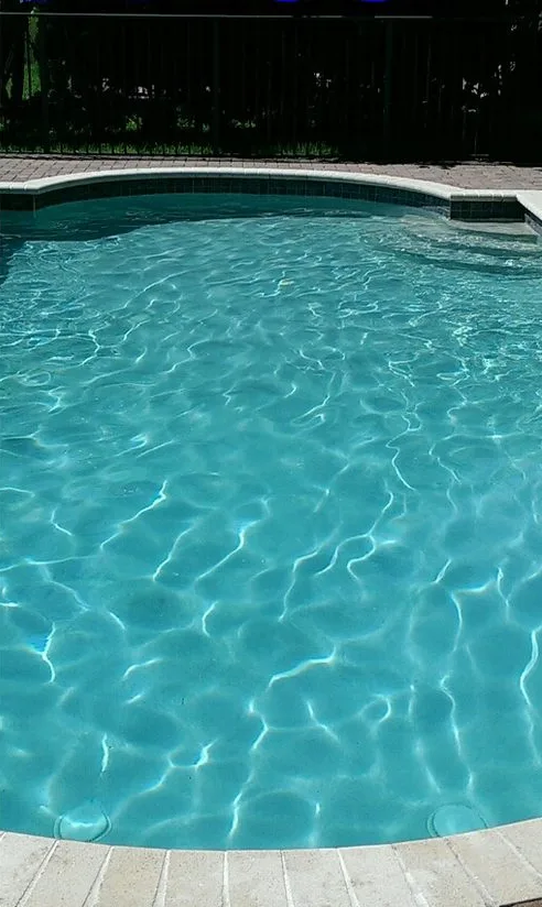 Clear blue pool water over a light plaster floor after a cleanup