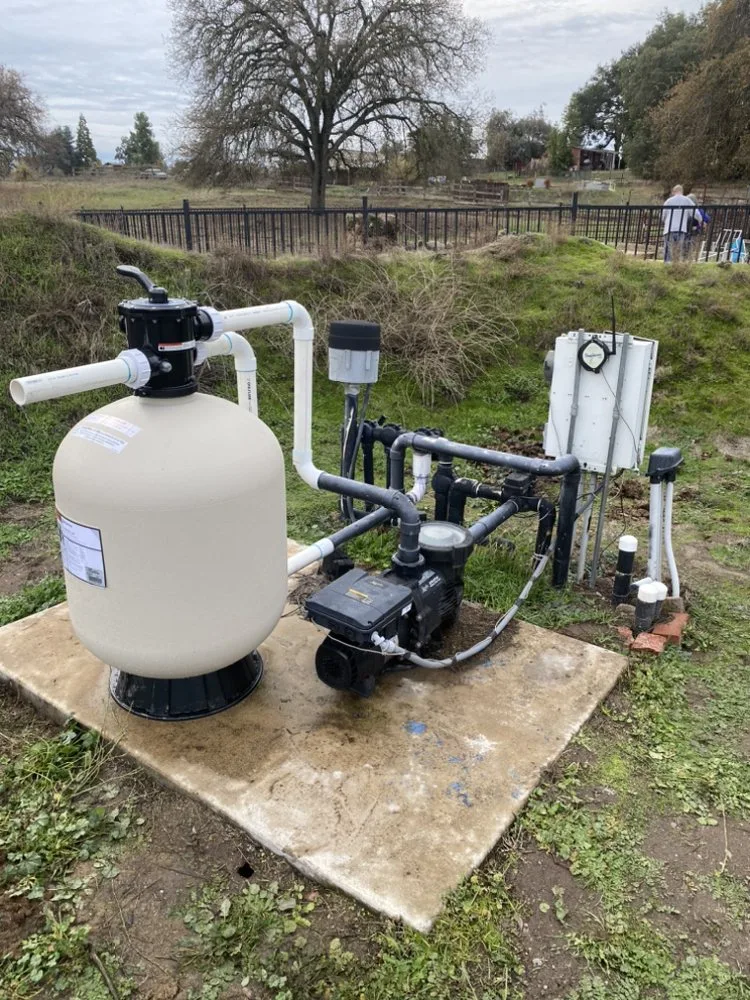 A new sand filter and pump installed on a concrete equipment pad